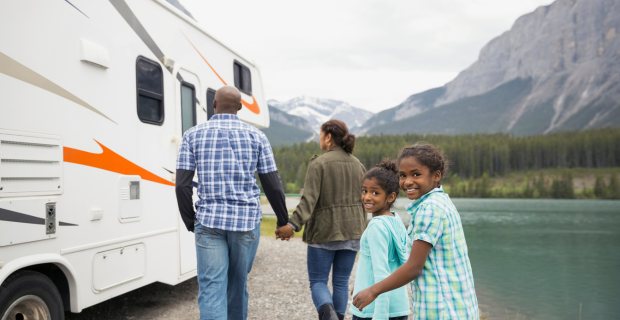 Family at lakeside walking toward RV.