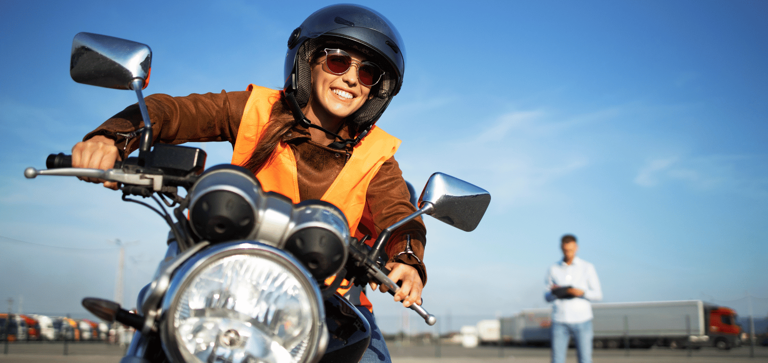 Une jeune femme conduit une moto lors d’un examen de conduite par une journée ensoleillée.