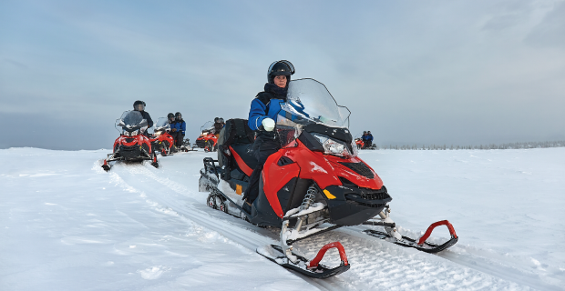 En motoneige en Finlande, une femme au-dessus du cercle arctique