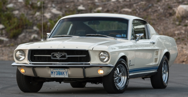 Une Ford Mustang de couleur crème stationnée à l’extérieur. 