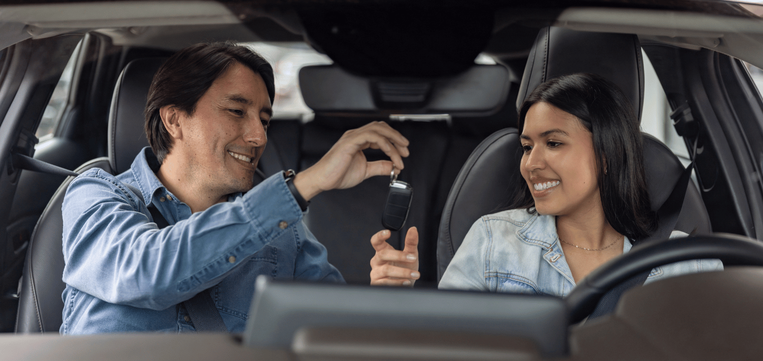 Un père remet les clés de la voiture à sa fille.