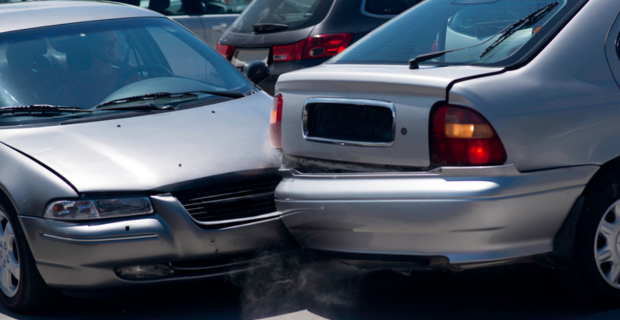 Une auto happe une autre auto en reculant dans un stationnement. 