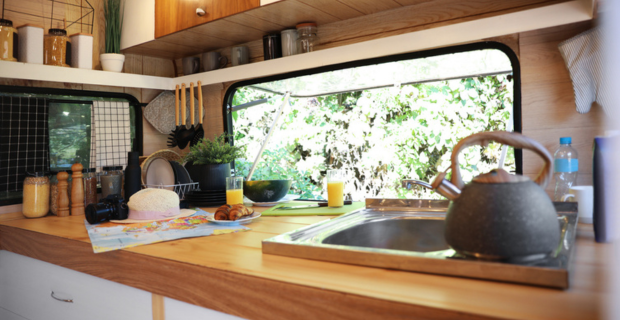 Cuisine chic avec différents accessoires et ustensiles dans une roulotte moderne. 