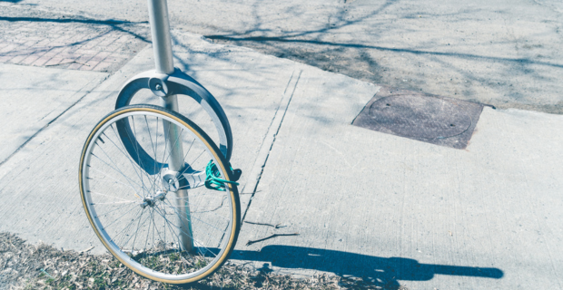 Tire locked to a post with the rest of the bike missing. 