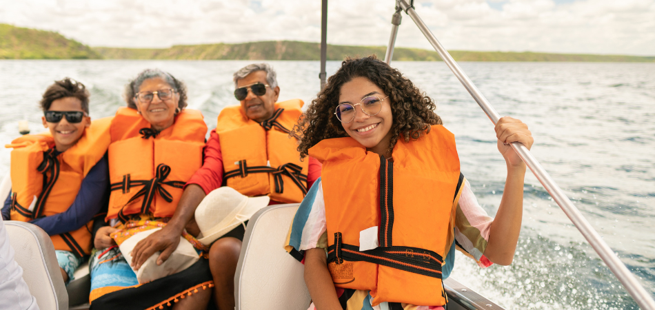 Des plaisancier.ère.s portant des gilets de sauvetage à bord d’un bateau en été, respectant les consignes de sécurité nautique.
