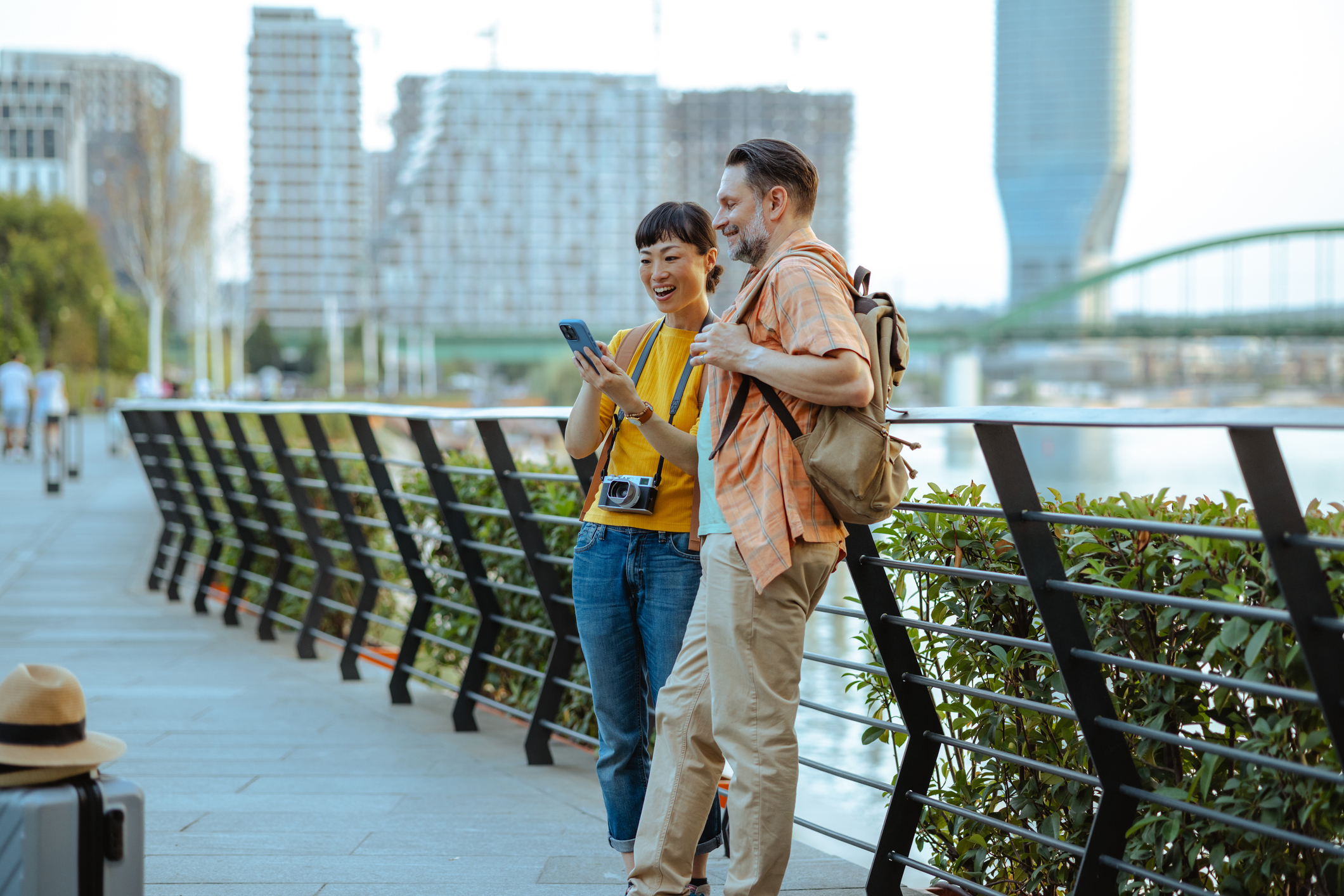 Un couple sourit et regarde un téléphone pendant ses vacances