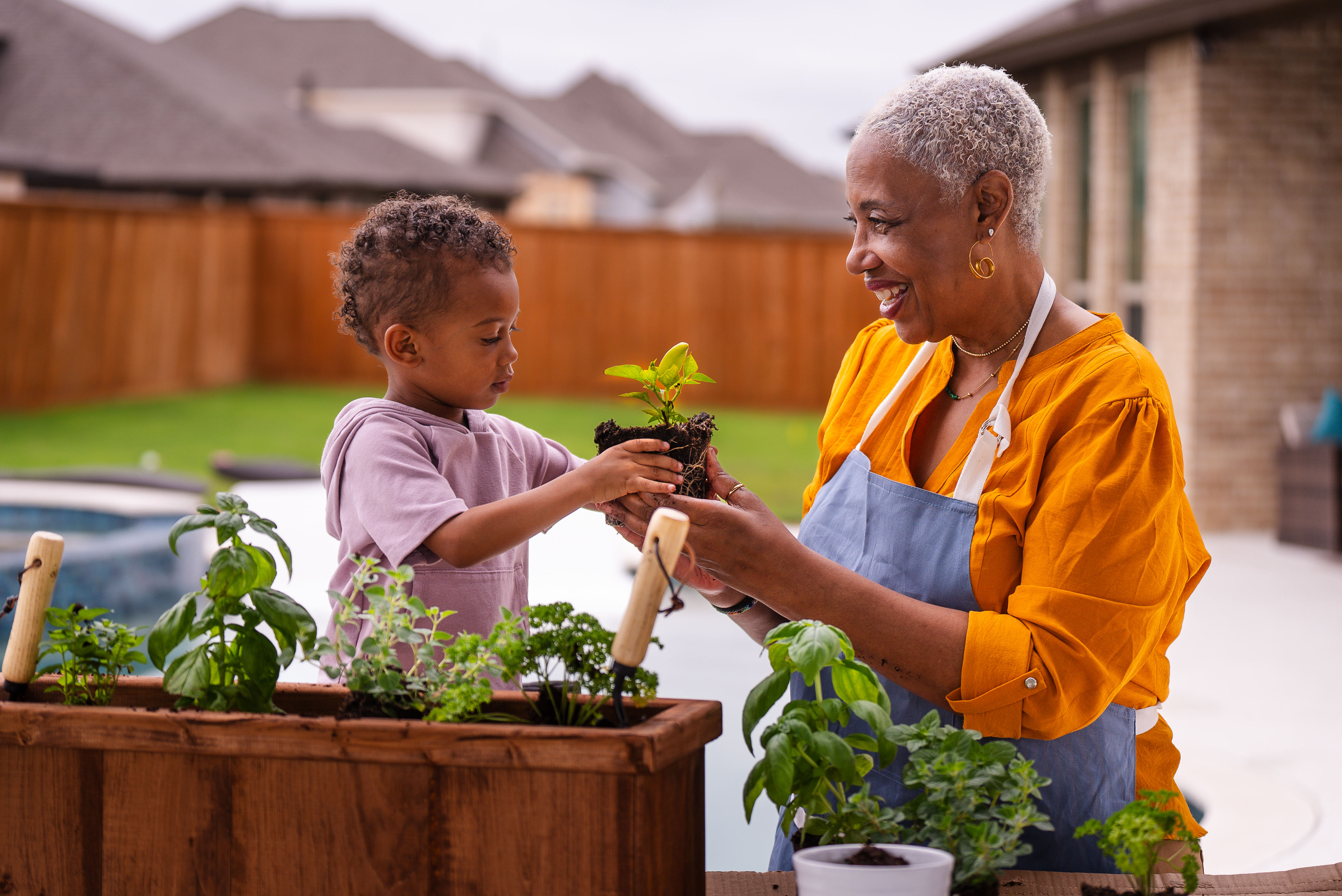 Une grand-mère jardinant à l’extérieur avec son petit-enfant