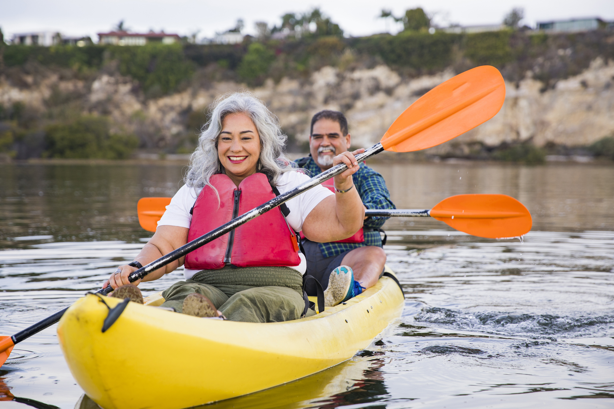 Un homme et une femme portant des gilets de sauvetage font du kayak