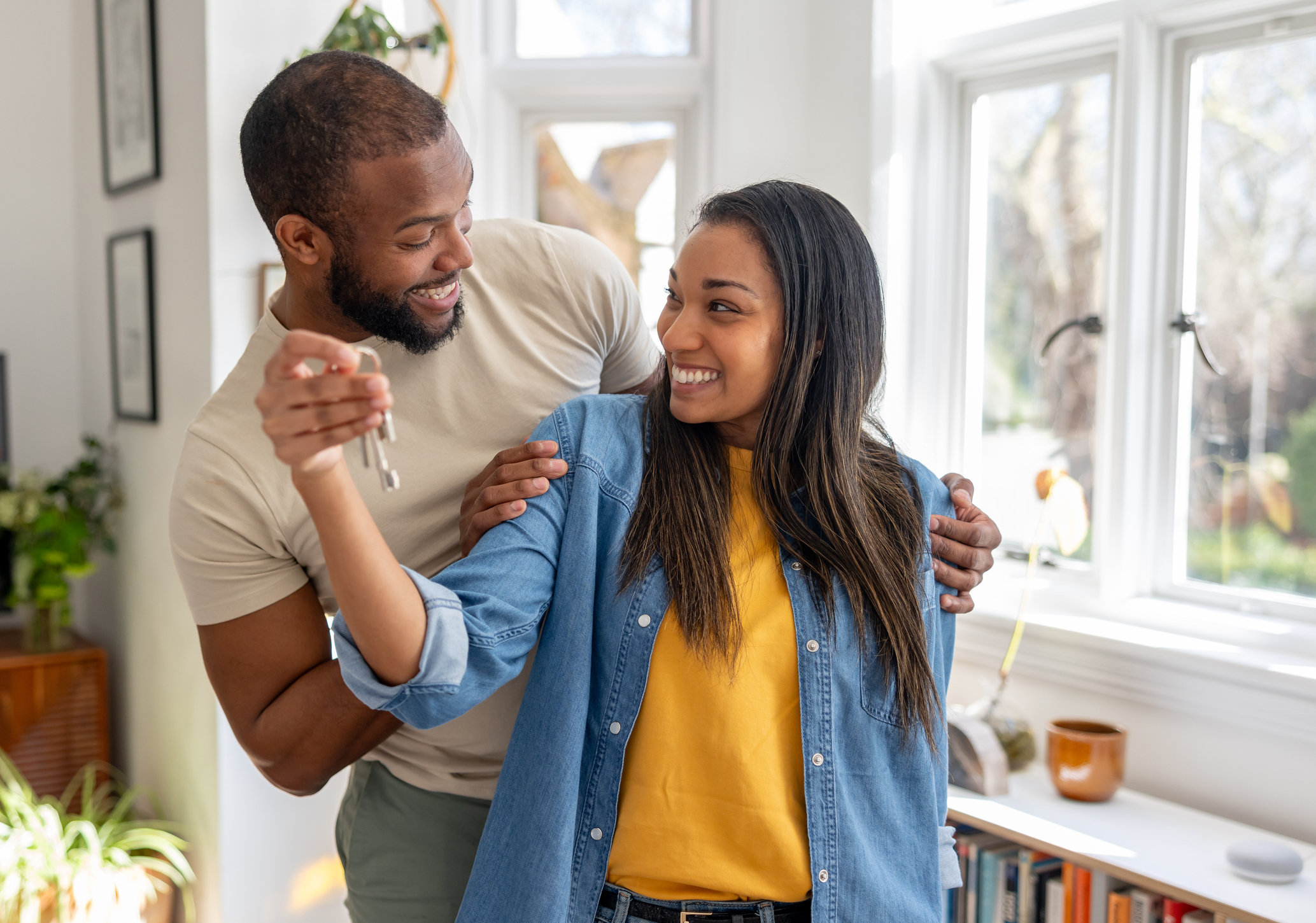 Un couple souriant tenant les clés de sa nouvelle maison