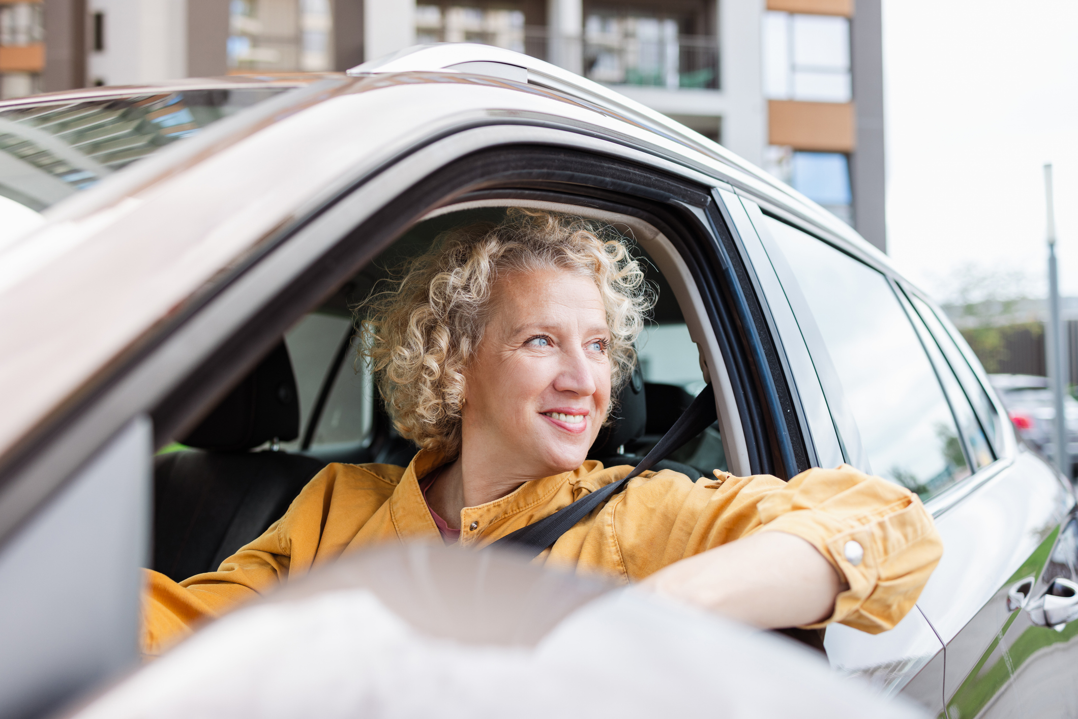 Une femme regardant par la fenêtre de sa voiture