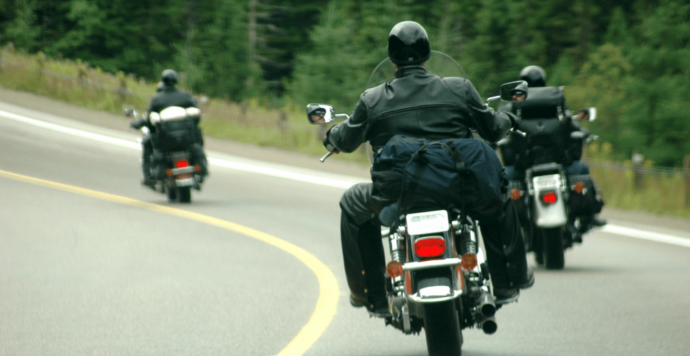 Trois personnes qui font de la moto ensemble sur une autoroute.