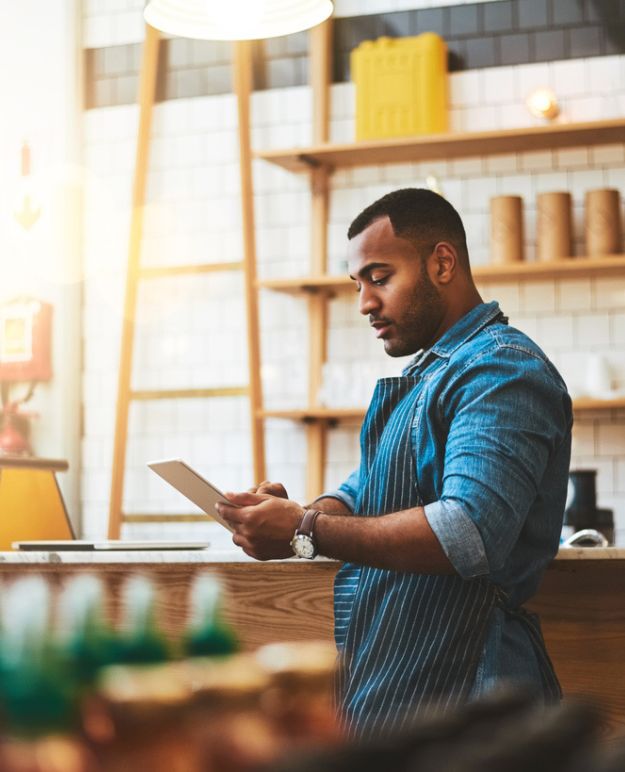 Un restaurateur examine son inventaire sur une tablette au comptoir.