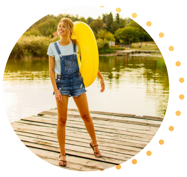 Une femme tenant une bouée jaune, debout sur le quai de sa cabine.