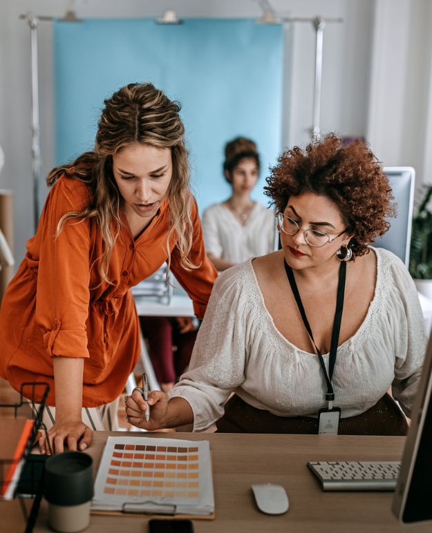 Deux femmes examinent des conceptions dans un bureau à aire ouverte.