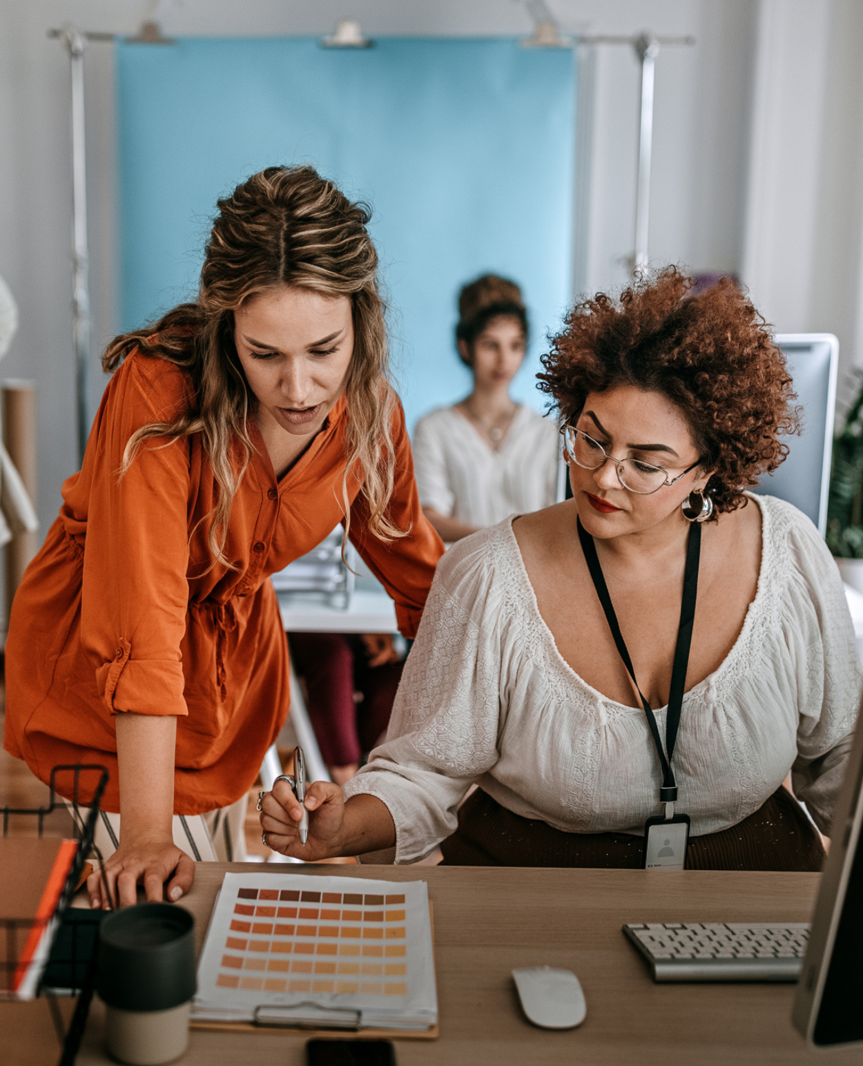 Deux femmes examinent des conceptions dans un bureau à aire ouverte.