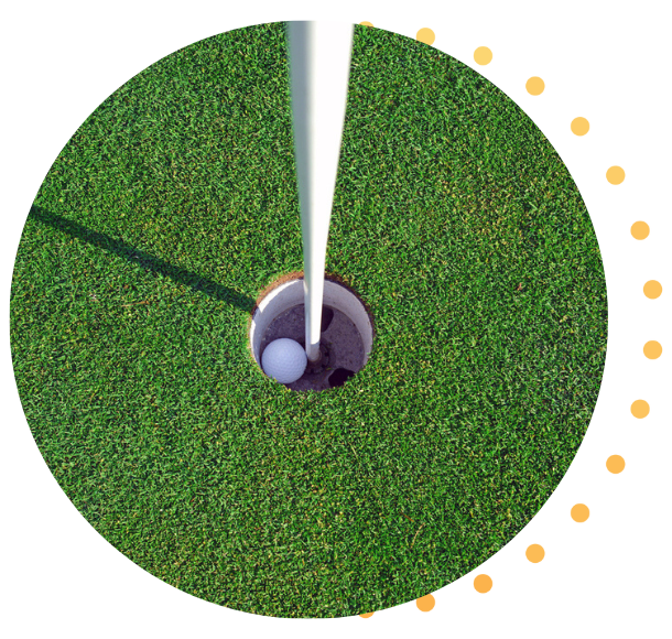Un gros plan d'une balle de golf dans le trou.