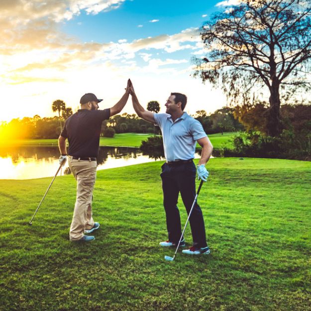 Deux amis font un high-five sur le green.