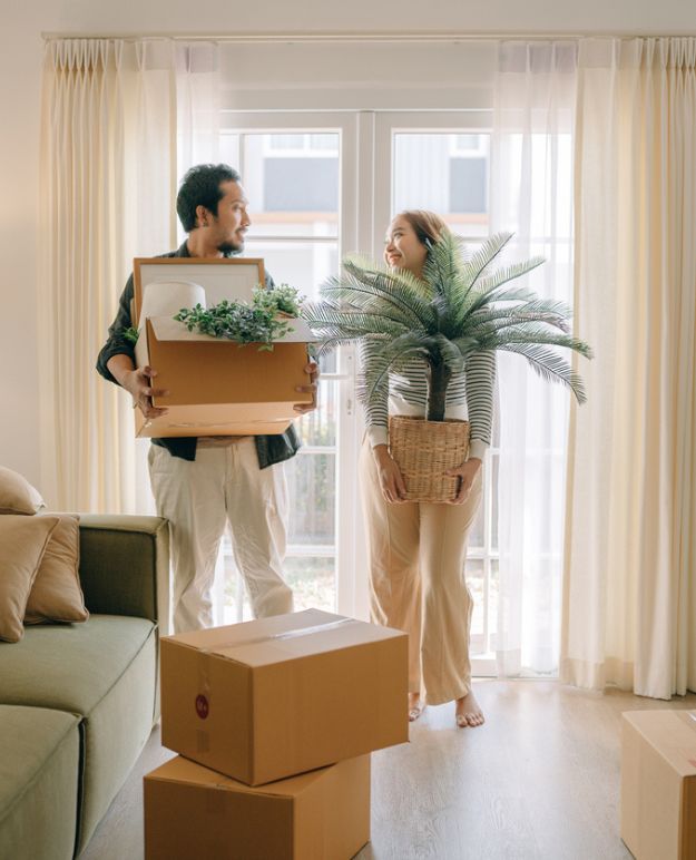 Un couple transportant des cartons dans leur nouvel appartement.