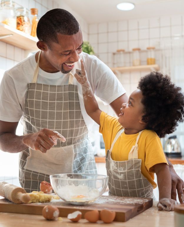 Un père et son enfant cuisinent ensemble dans la cuisine.