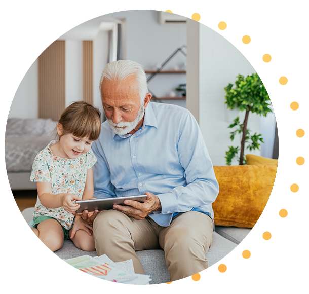 Homme d’âge mûr tenant de jeunes enfants sur ses genoux à l’extérieur, devant sa maison