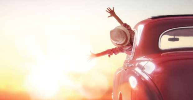 Une jeune femme est heureuse et fière au volant de sa Coccinelle